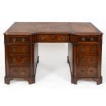 An early 20th century mahogany desk, the leather inset top above an arrangement of nine drawers, 137