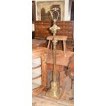 A late 19th/early 20th century brass standard lamp, with a reeded column, adapted for electricity,