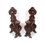 A pair of Italian carved walnut hall chairs See illustration Report by GH 100 cm high 32 cm wide