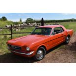A 1965 Ford Mustang coupé, unregistered, orange. Fords Mustang, the original Pony car based on the