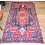 A Persian carpet, the central medallion on a red ground, 273 x 152 cm