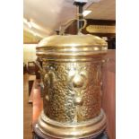 An Art Nouveau brass bin and cover, with embossed and hammered decoration, 51 cm high