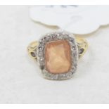 A dress ring, the central stone within a framework of diamonds, in a yellow coloured metal mount,