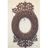 Two Burmese carved hardwood picture frames, decorated flowers and scrolling foliage, of oval form,