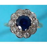 An 18ct gold ring, the central sapphire within a surround of ten diamonds, approx. ring size R See