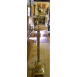 A late 19th/early 20th century brass standard lamp, with a reeded column, adapted for electricity,