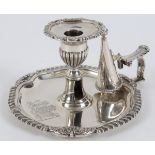 An early 19th century silver chamberstick, engraved an armorial and a double crest beneath a