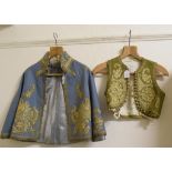 An 18th century style childs jacket, with gold coloured metal embroidery, and two similar waistcoats