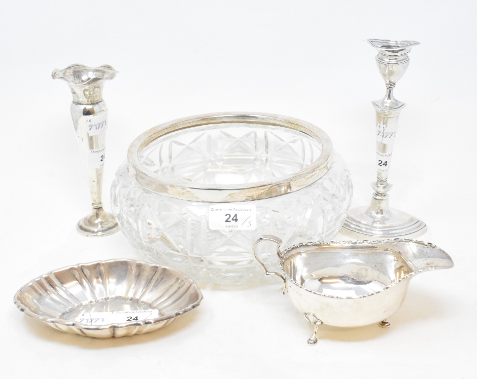 A silver sauce boat, Birmingham 1944, a silver coloured metal dish, a silver candlestick, a silver