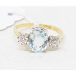 An 18ct gold ring, the central aquamarine flanked by two diamonds