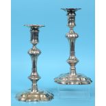 A pair of George II cast silver candlesticks, with detachable sconces, on spreading shaped square