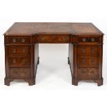 An early 20th century mahogany desk, the leather inset top above an arrangement of nine drawers, 137