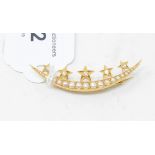 A crescent brooch, set seed pearls applied five gold stars with diamond centres, yellow coloured