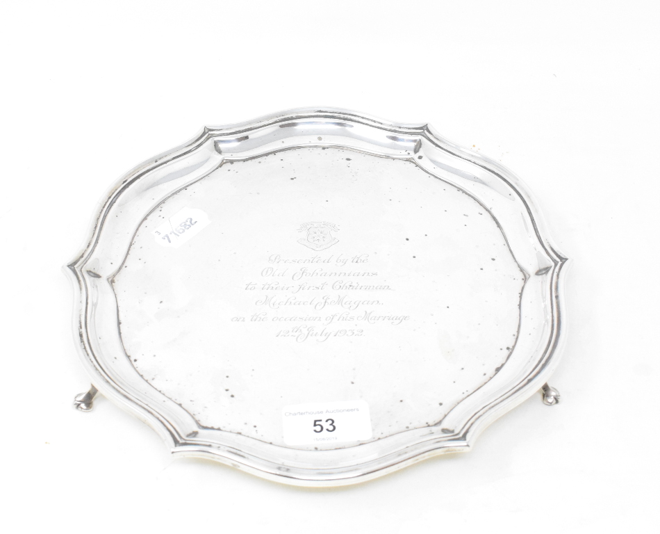 A silver salver, crested, and with a presentation inscription dated 1932, on three scroll feet,
