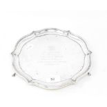 A silver salver, crested, and with a presentation inscription dated 1932, on three scroll feet,