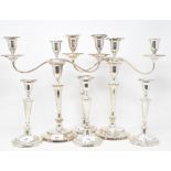 A pair of plated on copper three light candelabra, crested, and a set of four similar table
