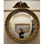 A Regency style convex wall mirror, surmounted an eagle, 73 cm wide