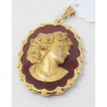 A 9ct gold and carnelian pendant, applied a gilt metal bust of a lady Report by NG The suspension