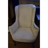 An 18th century style wingback armchair, on shell capped cabriole legs