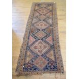 An Eastern runner, decorated geometric motifs on a blue ground, within a multi border, 232 x 86