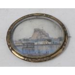 An oval brooch, inset a miniature painted a landscape