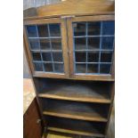 An oak bookcase, the top section having a pair of leaded glass doors, 69 cm wide