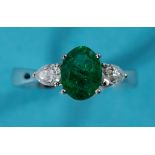 An 18ct white gold ring, the central emerald flanked by two diamonds, approx ring size M See