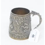 An Indian silver coloured metal mug, decorated figures in relief, inscribed and dated 1902, 8.5 cm