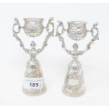 A pair of Continental silver coloured metal wager cups, with embossed decoration, 14 cm high Approx.