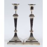 A pair of Victorian silver table candlesticks, of fluted form, on spreading square bases, London
