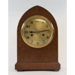 An early 20th century mantel clock, the 14 cm diameter silvered dial with Arabic numerals, in an oak