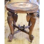 An Indian hardwood table, carved flowers and inlaid with bone, on four elephant head support legs,