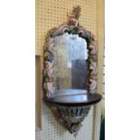 A German porcelain mounted mirror, decorated two putti, flowers and scrolling foliage, 35 cm wide