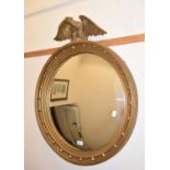 A Regency style convex wall mirror, surmounted an eagle, 73 cm wide