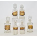 A set of six Victorian/Edwardian clear glass apothecary bottles, with gilt labels and cut glass