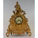 A late 19th century mantel clock, the 7 cm diameter dial with Arabric numerals, in a gilt spelter