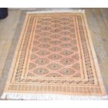 An Eastern rug, decorated geometric motifs on a pink ground, within a multi border, 187 x 129 cm,