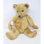 A plush teddy bear, with articulated arms, legs and head, with glass eyes, 1930's, 53 cm high Report