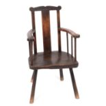 A 19th century oak primitive stick back armchair, with a solid splat, a solid seat, and tapering