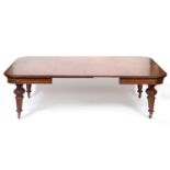 An early Victorian mahogany extending dining table, inset two extra leaves, on carved and tapering