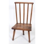 A 19th century child's primitive elm stick back chair, the solid seat on three legs See illustration