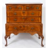 An 18th century style chest on stand, veneered in walnut and with feather crossbanding, having two