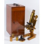 A Beck lacquered brass monocular microscope, with accessories, in a mahogany case, and a group of