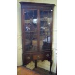An 18th century style corner cupboard on stand, having a pair of bar glazed doors, the stand on