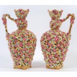 A pair of Zsolnay reticulated vases with handles, decorated flowers and foliage, on four splay