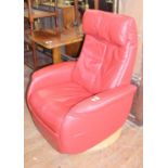 A red leather upholstered swivel armchair