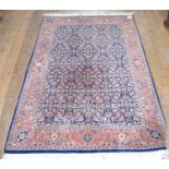 An Eastern rug, decorated birds and floral motifs on a dark blue ground, within a multi border,