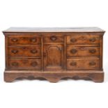 A 19th century oak dresser base, having an arrangement of seven drawers and a cupboard, 185 cm