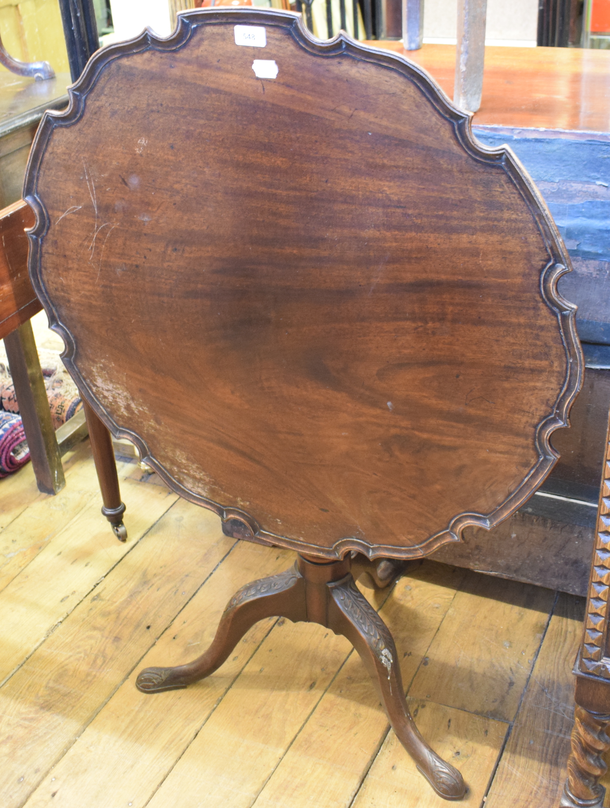 A mahogany tripod table, with a piecrust top, a fluted and reeded vase turned column and leaf carved