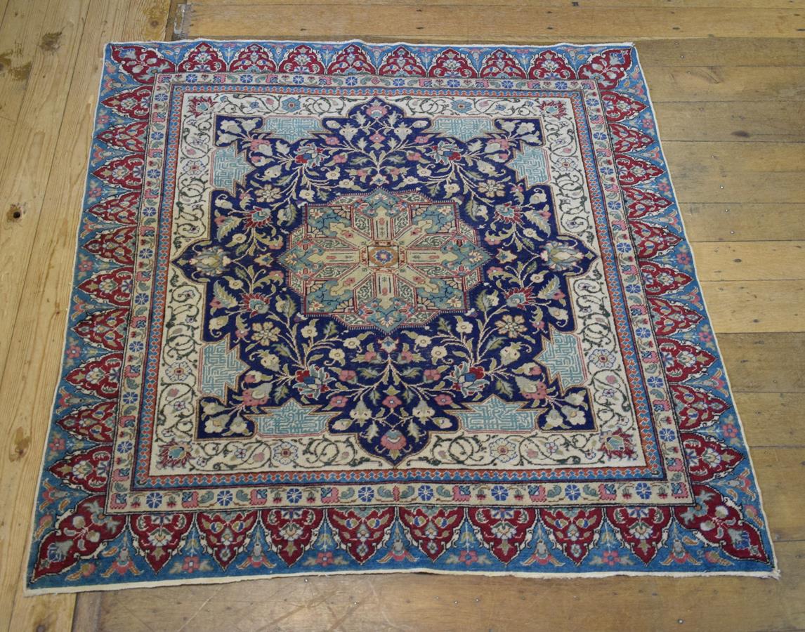An Anatolian rug, decorated a central medallion and floral motifs on a dark blue ground, within a